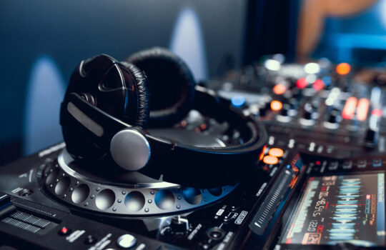 professional headphones on dj board in night club